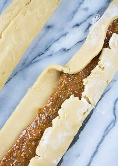 two long breads sitting on top of a marble countertop next to each other