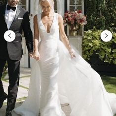 a man and woman in formal wear walking towards the camera with their wedding dress on