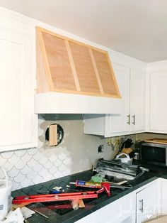 a kitchen with white cabinets and black counter tops that has been torn off by the wind