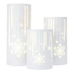 three white candles with snowflakes on them