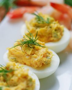 three deviled eggs with dill on them