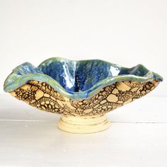 a blue and white bowl sitting on top of a wooden stand