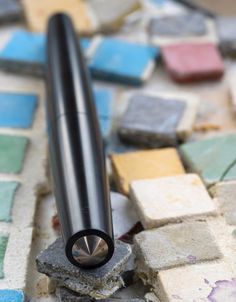 a black metal object sitting on top of colorful tiles