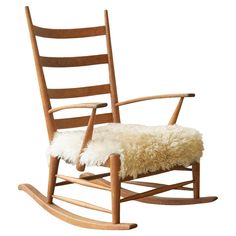 a wooden rocking chair with sheepskin on the seat