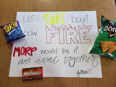 a sign that is on top of a table with some food and candy in front of it