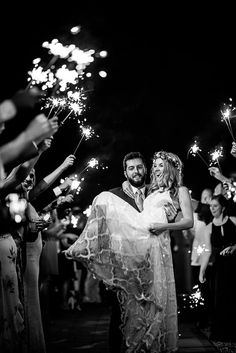 a bride and groom holding sparklers in their hands