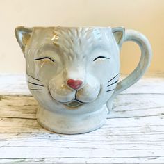 a ceramic mug with a cat's face on it