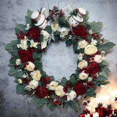 a wreath with flowers and baseball mitts on it next to some lit candles in the background