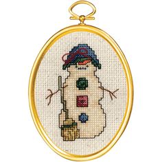 a cross stitch snowman ornament hanging from a gold frame