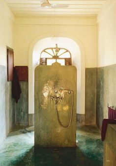 a large water fountain in the middle of a room with green flooring and walls