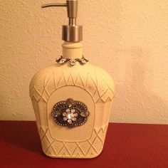 a soap dispenser sitting on top of a red table next to a wall