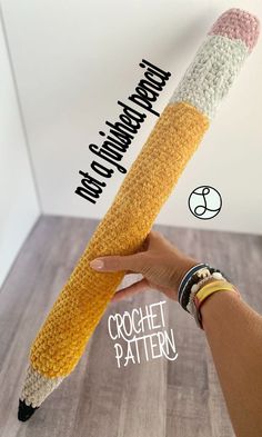 a crocheted pencil is held up to show the word happy birthday written on it