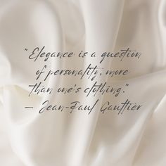 an image of a quote written on white satin fabric with the words elegance is a question of personality, none than one's clothing - jean paul gaither