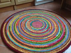 a multicolored round rug is on the floor in front of a stove top