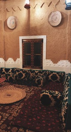 a living room with couches and rugs in front of a window on the wall