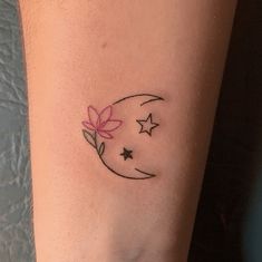 a small tattoo on the arm of a woman with stars and a flower in it