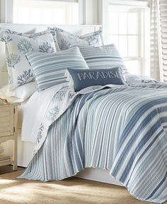 a bed with blue and white comforters in a bedroom