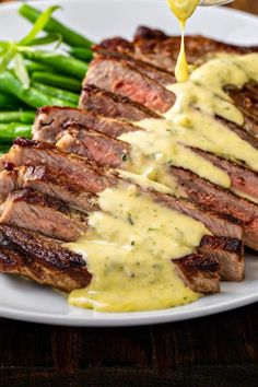 a white plate topped with steak and green beans