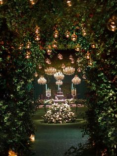 an elaborate garden with chandeliers and flowers in the center is lit by candles