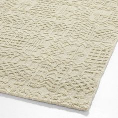 a white rug with an intricate design on the bottom, and a light colored background