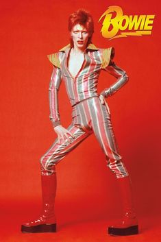 a man with red hair and striped suit posing for a magazine cover, in front of a red background