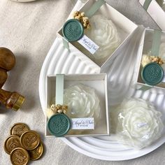 three cupcakes in small boxes on a plate with some gold coins around them