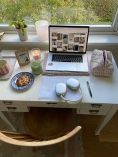 an open laptop computer sitting on top of a desk next to a cup and saucer