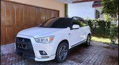 a white car parked in front of a house