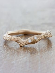 a gold branch ring with three diamonds on it