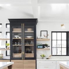 a kitchen with black cabinets and white counter tops