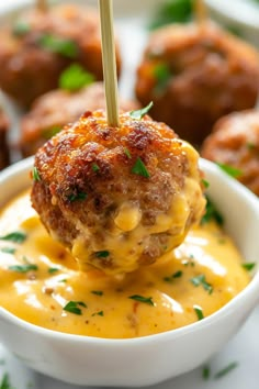 a bowl filled with cheese covered meatballs