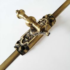 an ornate brass handle on a white background