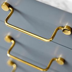 a close up of a metal drawer with gold handles