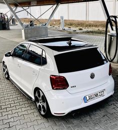 a white car parked in front of a gas station