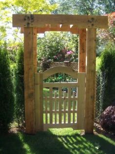 a wooden gate in the middle of a garden