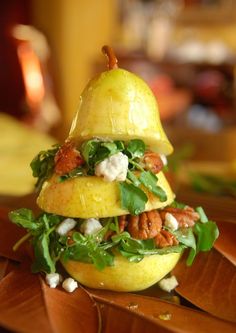 a sandwich made out of fruit and vegetables on a wooden table with other food items