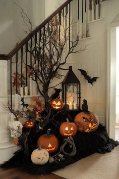 a staircase decorated with halloween decorations and pumpkins on the top, next to a lantern