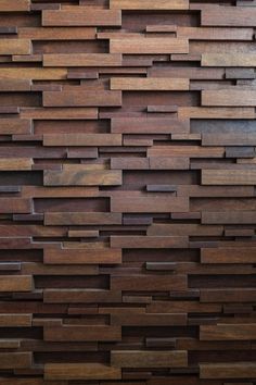 a wall made out of wooden planks with different colors and shapes on it's sides