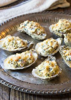 several oysters with cheese and herbs on a plate