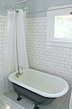 an old fashioned bathtub in a white tiled bathroom