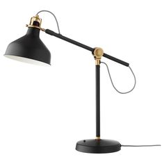 a black and gold desk lamp with a white light on the top, one arm is plugged into an outlet