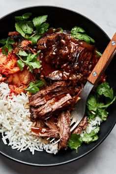 a black bowl filled with rice and meat