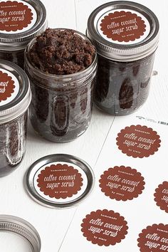 jars filled with brownie cookies sitting on top of a white table next to stickers