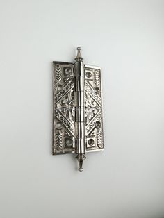 an ornate metal door handle on a white wall