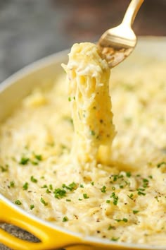 a ladle full of macaroni and cheese being held up