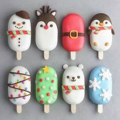 there are six pops decorated like animals and snowmen on the top one is wearing a santa claus hat