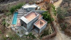 an aerial view of a house with a pool in the yard and trees surrounding it