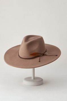 Our Marin wide-brimmed hat will never go out of style. From its iconic teardrop, pinch-front crown to its corded hatband accented with a feathered flourish, the Marin was designed to make a statement. With its prominent 22" circumference, Marin strikes an unmistakable silhouette while shading you from the sun. An inner drawstring sweatband adjusts for the perfect fit, making this any season's must-have accessory. Wide Brim Fedora With Feathers For Kentucky Derby, Adjustable Fedora With Feather Trim For Kentucky Derby, Curved Brim Fedora With Feather Trim For Kentucky Derby, Adjustable Brimmed Fedora With Feathers, Flat Brim Hat With Feather Trim For Country Events, Feathered Fedora With Curved Brim For Fall, Winter Adjustable Fedora With Feathers, Adjustable Feather Fedora For Fall, Adjustable Wide Brim Fedora With Feather Trim