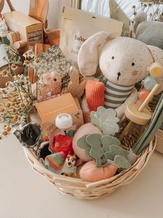 a basket filled with lots of stuffed animals and other items on top of a table