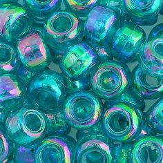 many different colors of glass beads are shown in this close up photo, including blue and green